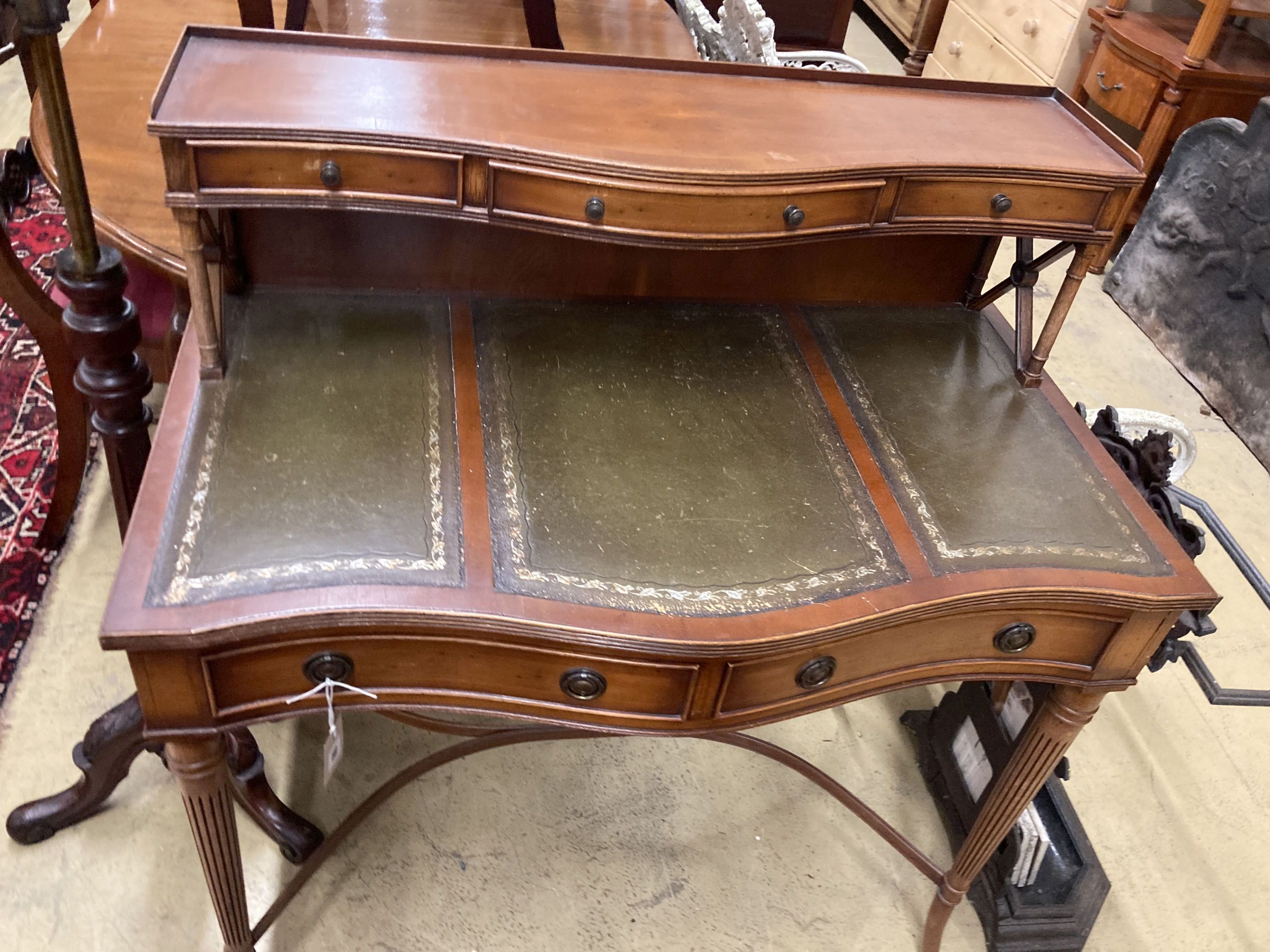 A reproduction yew serpentine writing table, width 92cm, depth 50cm, height 103cm